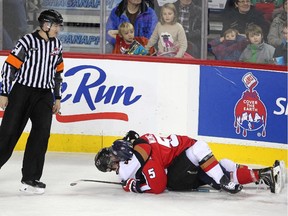 Referee Derek Zalaski, left, looked on as Calgary Hitmen defenceman Michael Zipp and Lethbridge Hurricanes centre Tyler Wong scrapped on the ice during a line brawl last season. Wong scored two goals against the Hitmen on Wednedsay night to lead the Hurricanes to a 6-4 win.