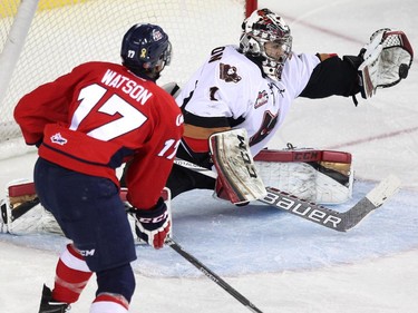 Calgary Hitmen goalie Evan Johnson stretched to glove a shot by Lethbridge Hurricanes left winger Jamal Watson during WHL action at the Scotiabank Saddledome on December 30, 2014.