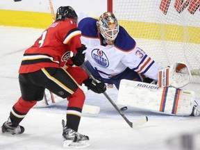 Calgary Flames Johnny Gaudreau, left, scores on Edmonton Oilers goalie Viktor Fasth during first period action at the Scotiabank Saddledome in Calgary on December 27, 2014.