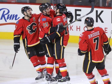 Mark Giordano, Sean Monahan, and David Jones of the Calgary Flames celebrate after a goal against the Arizona Coyotes at Scotiabank Saddledome in Calgary on Tuesday December 2, 2014.