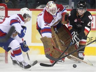 Connor Rankin of the Calgary Hitmen battles Edmonton Oil King goalie Tristan Jarry for a loose puck in  the first period at the Saddledome Friday night December 5, 2014.