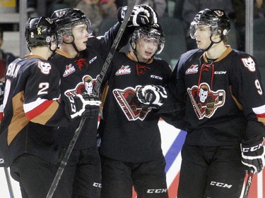 Connor Rankin of the Calgary Hitmen, centre, is mobbed by teammates, Jake Bean, 2, Jake Virtanen and Pavel Karnaukhov, right, after opening the scoring in the first period against the Edmonton Oil Kings at the Saddledome Friday night December 5, 2014.