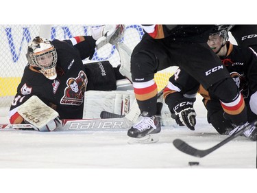 Calgary Hitmen goalie Mack Sheilds eyes a puck bouncing in front of the net during the first period against the Edmonton Oil Kings at the Saddledome Friday night December 5, 2014.