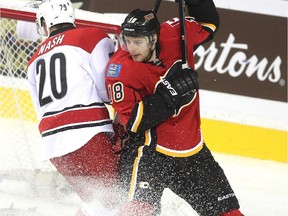 Flames centre Matt Stajan battled against Carolina Hurricanes centre Riley Nash outside the Hurricanes net during first period NHL action at the Scotiabank Saddledome on October 23, 2014.