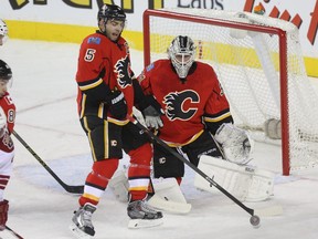 Mark Giordano of the Calgary Flames helps out goaltender Karri Ramo against the Arizona Coyotes at Scotiabank Saddledome in Calgary on Tuesday December 2, 2014.