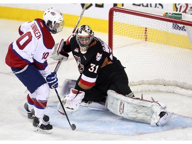 Calgary Hitmen goalie Mack Shields keeps his eye on the puck after a shot by Edmonton Oil Kings left winger Tyson Gruninger took a shot on net during first period WHL action at the Scotiabank Saddledome on December 17, 2014.