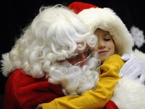 Gavin Buechner, 6, gets a hug from Santa, whose travels may be curtailed if Ottawa ever has its way.
