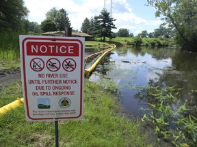 A sign at the confluence of Talmadge Creek and the Kalamazoo River warns residents that thousands of gallons of oil from a ruptured pipeline operated by Enbridge Inc. spilled into the Kalamazoo.