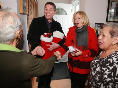 Laureen Harper and Dave Kelly deliver a special Christmas Meals on Wheels complete with Christmas stockings to Arturo and Bertha Flores on Friday December 19, 2014.