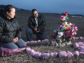 John Sedo and Geraldine Bearspaw place gifts at the memorial to their daughter Brittany Bearspaw, who died Jan. 1, 2006, when she was struck by three vehicles on the Trans-Canada Highway.