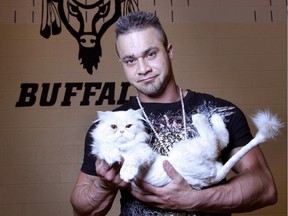 Wrestler Teddy Hart, grandson of Stu Hart, is pictured with his cat Mr. Money at the Tsuu T'ina reserve in Calgary, Alberta on September 8, 2011.