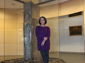 Teresa Posyniak stands with her sculpture, Lest We Forget, a memorial dedicated 20 years ago in memory of the victims of the Montreal Massacre,  in Calgary on Dec. 2, 2014.