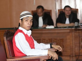 Child sexual abuse suspect Virgiawan Amin sits on the defendant's chair during his trial at South Jakarta District Court in Jakarta, Indonesia, Monday, Dec. 22, 2014. An Indonesian court has sentenced five janitors to up to eight years in prison over the rape of a kindergartner at prestigious school in Indonesia.