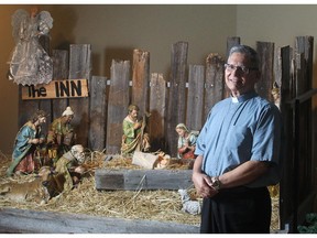 Father Julian Studden of St. Michael Catholic Church in Wentworth beside the church's nativity scene Wednesday December 17, 2014.