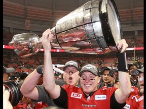 Calgary Stampeders quarterback Bo Levi Mitchell holds the Grey Cup after the team won the 2014 Grey Cup in Vancouver on Sunday November 30, 2014.
