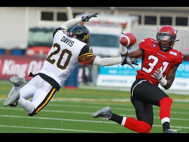 Stampeders receiver Jeff Fuller could not quite hold on to this pass as Ti-Cats defensive back Emanuel Davis jumps to block in the first quarter of their CFL game at McMahon Stadium in Calgary on Friday evening July 18, 2014.  The two teams would meet again in the Grey Cup in November and the Stamps would win.