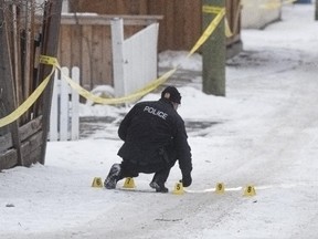 Police investigate after a body was found in the alleyway of the 1400 block of 8th Street N.W. in Calgary, on January 2, 2015.