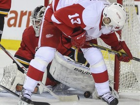 Calgary Flames' goalie Karri Ramo stops the puck as Detroit Red Wings' Pavel Datsyuk checks between his legs to see if he's scored during Wednesday's game. Ramo later left the contest after colliding with defenceman Raphael Diaz.