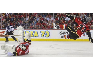 Calgary Flames goalie Karri Ramo skates way out to make the poke check on a race for the puck between the Detroit Red Wings and Calgary Flames' Raphael Diaz, and Diaz goes flying after the collision which sent Ramo to the locker room, during game action at the Saddledome in Calgary, on January 7, 2015.
