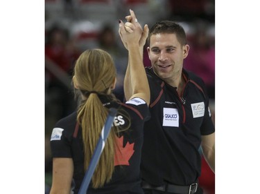 John Morris and Kaitlyn Lawes high five after winning their mixed doubles match against Team Europe's David Murdoch and Eve Muirhead during Continental Cup action at the Markin MacPhail Centre in Calgary, on January 10, 2015.The final score was 8-5 for Team Canada.