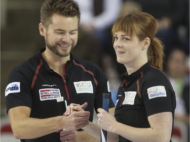 Husband-and-wife mixed doubles team Dawn and Mike McEwen high five after winning an end during mixed doubles Continental Cup action at the Markin MacPhail Centre in Calgary, on January 10, 2015. Team Europe overtook them in this 6-5 nail-biter match.