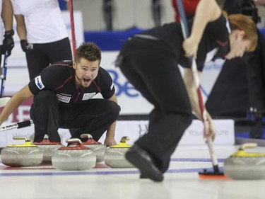 Mike McEwen yells for his mixed doubles partner and wife, Dawn McEwen, to sweep harder as Team Europe's Anna Sloan watches from behind during mixed doubles Continental Cup curling action at the Markin MacPhail Centre in Calgary, on January 10, 2015. Team Europe overtook them in this 6-5 nail-biter match.