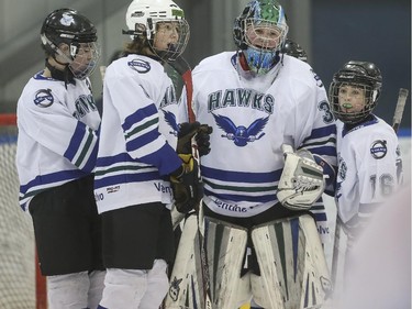 The Glenlake Hawks, of the PeeWee hockey league, congratulate their goalie, Max Prazma, after winning their first match, 2-0, on the first day of the Esso Minor Hockey Week in Calgary, on January 10, 2015. The 36th annual EMHW will be held at rinks across the city from January 10 to 18, 2014.
