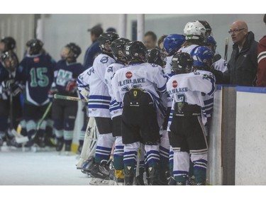The Midnapore Mavericks, back left, and the Hawks get a pep talk from their coaches at the second intermission during the first day of the Esso Minor Hockey Week in Calgary, on January 10, 2015. The 36th annual EMHW will be held at rinks across the city from January 10 to 18, 2014.