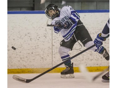 Glenlake Hawks' Nathan Quinn clears the puck from his end during the first day of Esso Minor Hockey Week in Calgary, on January 10, 2015. The 36th annual EMHW will be held at rinks across the city from January 10 to 18, 2014.