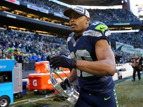 Doug Baldwin #89 of the Seattle Seahawks runs off the field with the George S. Halas trophy after the Seahawks 28-22 overtime victory against the Green Bay Packers.