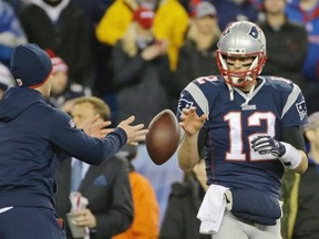 New England Patriots quarterback Tom Brady has a ball tossed to him during warm-ups prior to Sunday’s AFC Championship Game against the Indianapolis Colts in Foxborough, Mass. The NFL continues to investigate whether the Patriots used underinflated footballs in the game after a report claimed the league found 11 balls were not properly inflated.