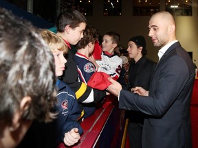 Calgary Flames Johnny Gaudreau and Mark Giordano sign autographs on the red carpet for the 2015 NHL All-Star Weekend at Nationwide Arena on Saturday in Columbus, Ohio. On Tuesday night, it's back to reality as the Flames resume their drive for a playoff spot against the Buffalo Sabres.
