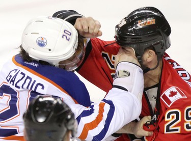 Edmonton Oilers Luke Gazdic, left and Calgary Flames Deryk Engelland fight it out during their game at the Scotiabank Saddledome  in Calgary on January 30, 2014.