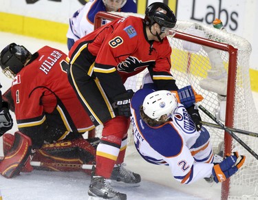 Edmonton Oilers goalie Ben Scrivens, right, blocks a shot on net from Calgary Flames Andrew Ference during their game at the Scotiabank Saddledome  in Calgary on January 30, 2014.
