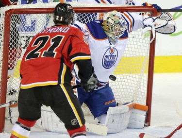 Edmonton Oilers Ben Scrivens blocks a shot from Calgary Flames Mason Raymond.