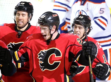 Calgary Flames Sean Monahan, middle, celebrates his goal on Edmonton Oilers with teammates Johnny Gaudreau, right and David jones, left, during their game at the Scotiabank Saddledome in Calgary on January 30, 2014.