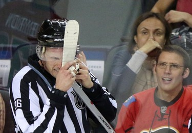 Linesmen David Brisebois gets Edmonton Oilers Anton Lander's stick caught in his helmet during their game at the Scotiabank Saddledome in Calgary on January 30, 2014.