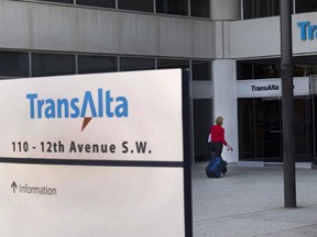 A woman walks towards the entrance of the TransAlta headquarters building in Calgary.