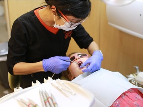 Dental Hygienist Andrea Chia examines Lauralei Kopp's teeth on the Alex Dental Health bus.