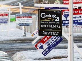 Real estate signs line Arbour Lake Road outside of the Arbour Lake Landing townhouse development on Thursday Jan. 22, 2015