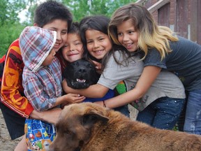 Some children at Saddle Lake enjoy a visit by the Alberta Spay/Neuter Task Force last June.