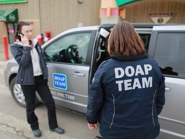 DOAP team outreach worker Chelsea Houston, left, answers a call while Jill Kirk helps two men and one woman into their van after security found them intoxicated at Marlborough Mall.