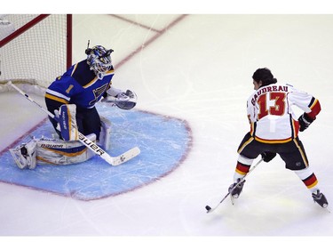 Calgary Flames' Johnny Gaudreau (13), of Team Toews, gets a shot off between his legs in front of St. Louis Blues goalie Brian Elliott, of Team Foligno, during the Breakaway competition at the NHL All-Star hockey skills competition in Columbus, Ohio, Saturday, Jan. 24, 2015.