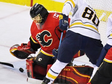 The Calgary Flames'  Jonas Hiller reaches to grab the puck during NHL action at the Scotiabank Saddledome on Tuesday Jan. 27, 2015.