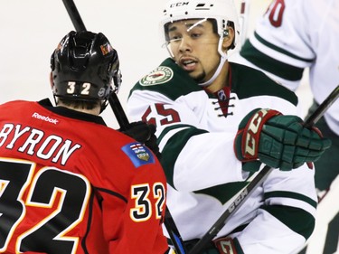 Minnesota Wild defenceman Matt Dumba and Flames centre Paul Byron jostle during the first period of NHL action at the Scotiabank Saddledome on Thursday Jan. 29, 2015.
(