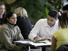 Flood victim Surinder Randhawa and his wife Kuljit work with a disaster claim's case worker at the Centre Street Church in Calgary in 2007.