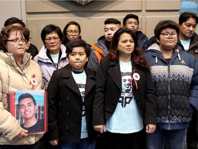 Grace Pesa, second from right, stands with family and friends as she talks to media about the impact of her son's death  on the family, at the Calgary Courts Centre on January 8, 2015.