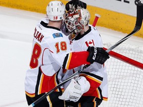 Goaltender Joni Ortio #37 of the Calgary Flames is congratulated by Matt Stajan #18 of the Calgary Flames after defeating the Arizona Coyotes 4-1 in the NHL game at Gila River Arena on January 15, 2015 in Glendale, Arizona.