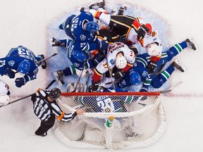 Goalie Ryan Miller #30 of the Vancouver Canucks covers up the puck as Henrik Sedin #33 , Kevin Bieksa #3 Alexander Edler #23 and Daniel Sedin #22 of the Vancouver Canucks battle with Lance Bouma #17, Matt Stajan #18 and T.J. Brodie #7 of the Calgary Flames during the second period in NHL action in Vancouver, BC,  on December, 20, 2014 at Rogers Arena in Vancouver.