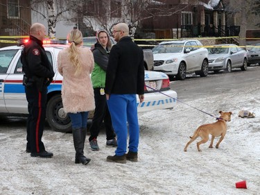 Police at the scene of a multiple shooting in Calgary on January 1, 2015, talk to residents who live in the crime scene area.